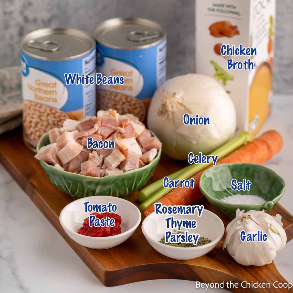 A display of ingredients used for making a soup with white beans and bacon.