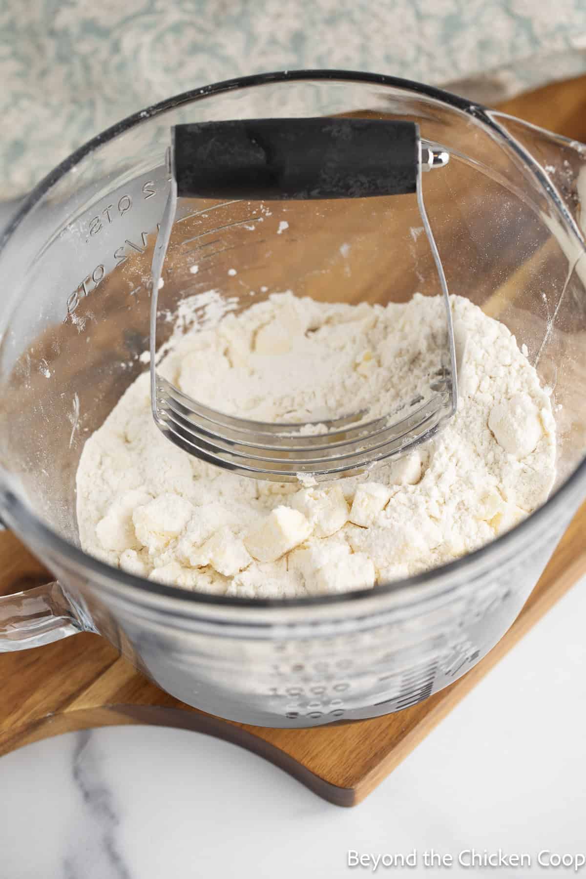 Mixing butter into flour with a pastry blender.