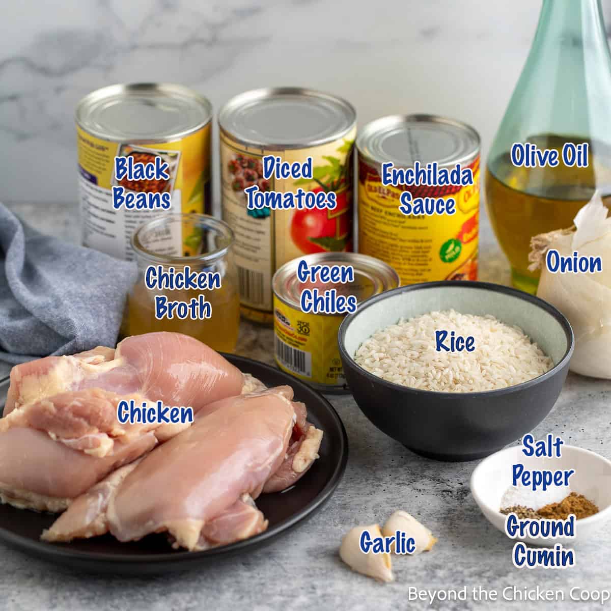 Ingredients for making a dish with rice, chicken, beans, and enchilada sauce.