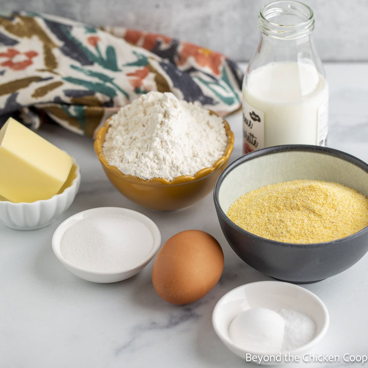 Small bowls filled with flour, cornmeal, butter, and sugar.