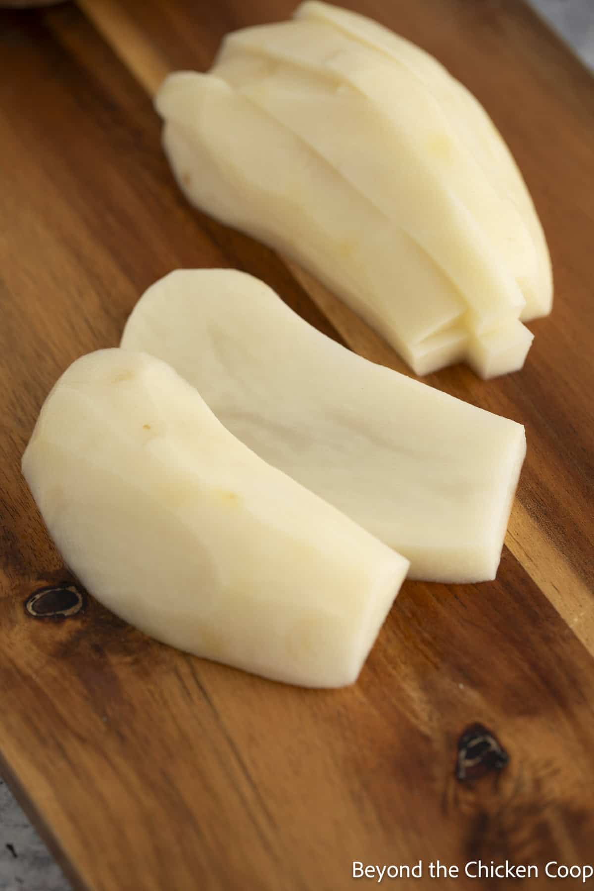 Sliced potato on a wooden board.