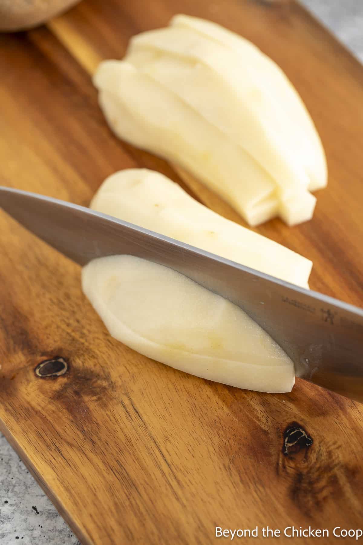 Slicing potatoes into thin strips.