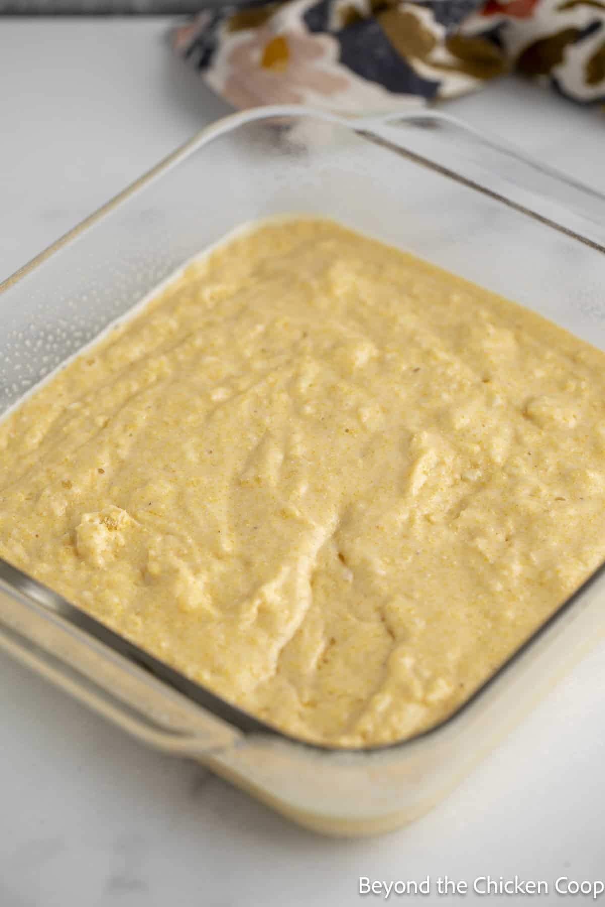 Unbaked cornbread in a glass dish.
