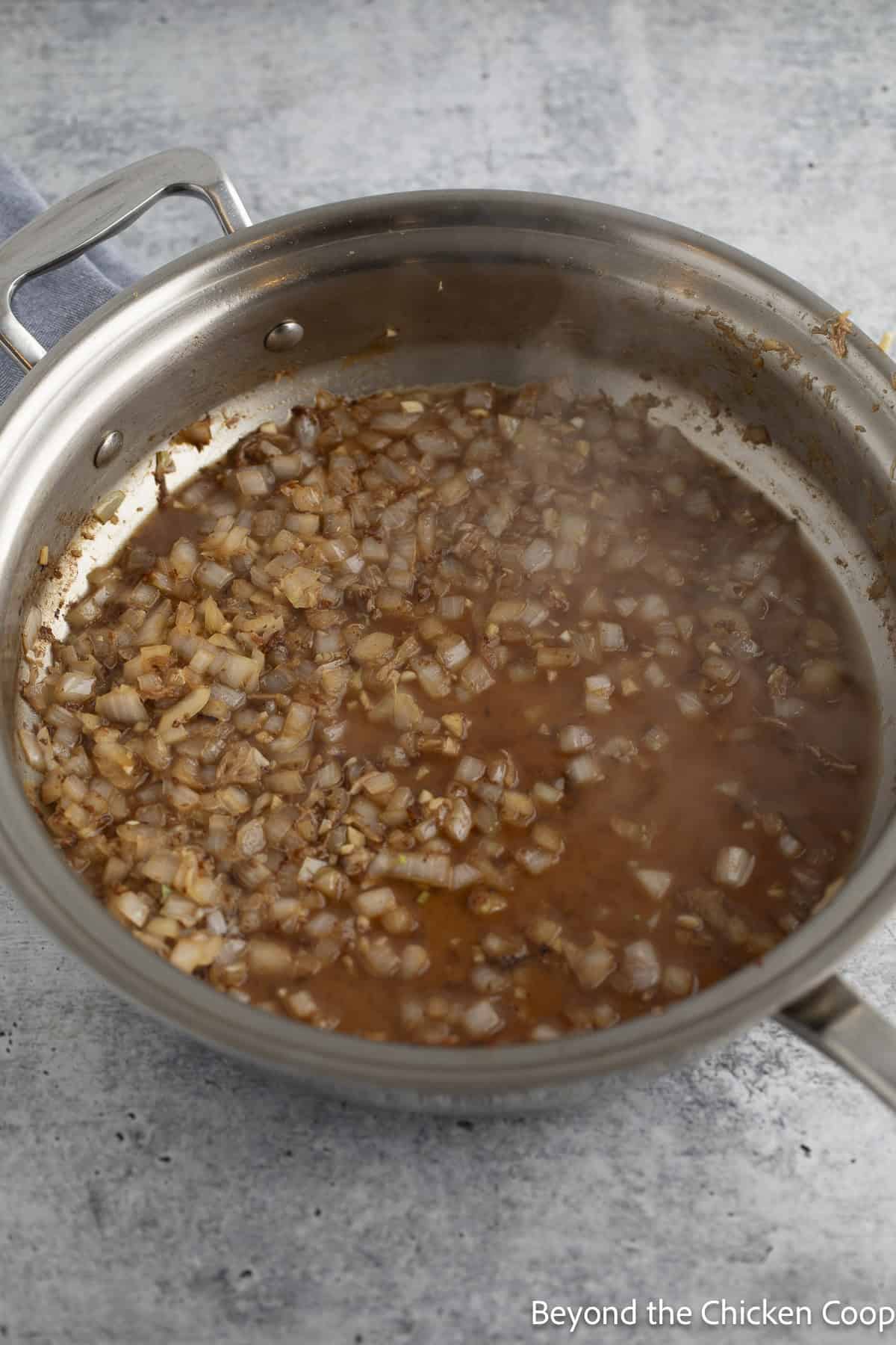 Deglazing a pan filled with diced onions.