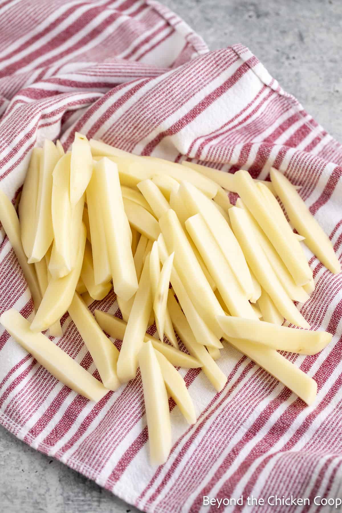 Drying uncooked fries with a towel.