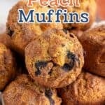 A basket filled with muffins with blueberries and peaches.