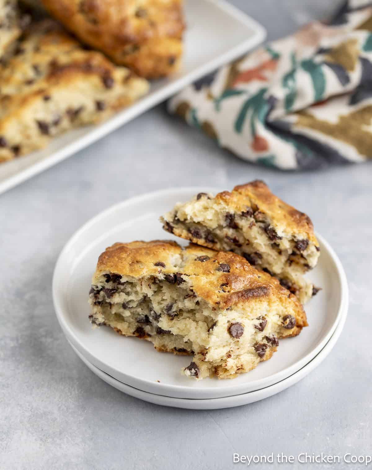 A scone broken into two pieces on a small white plate.