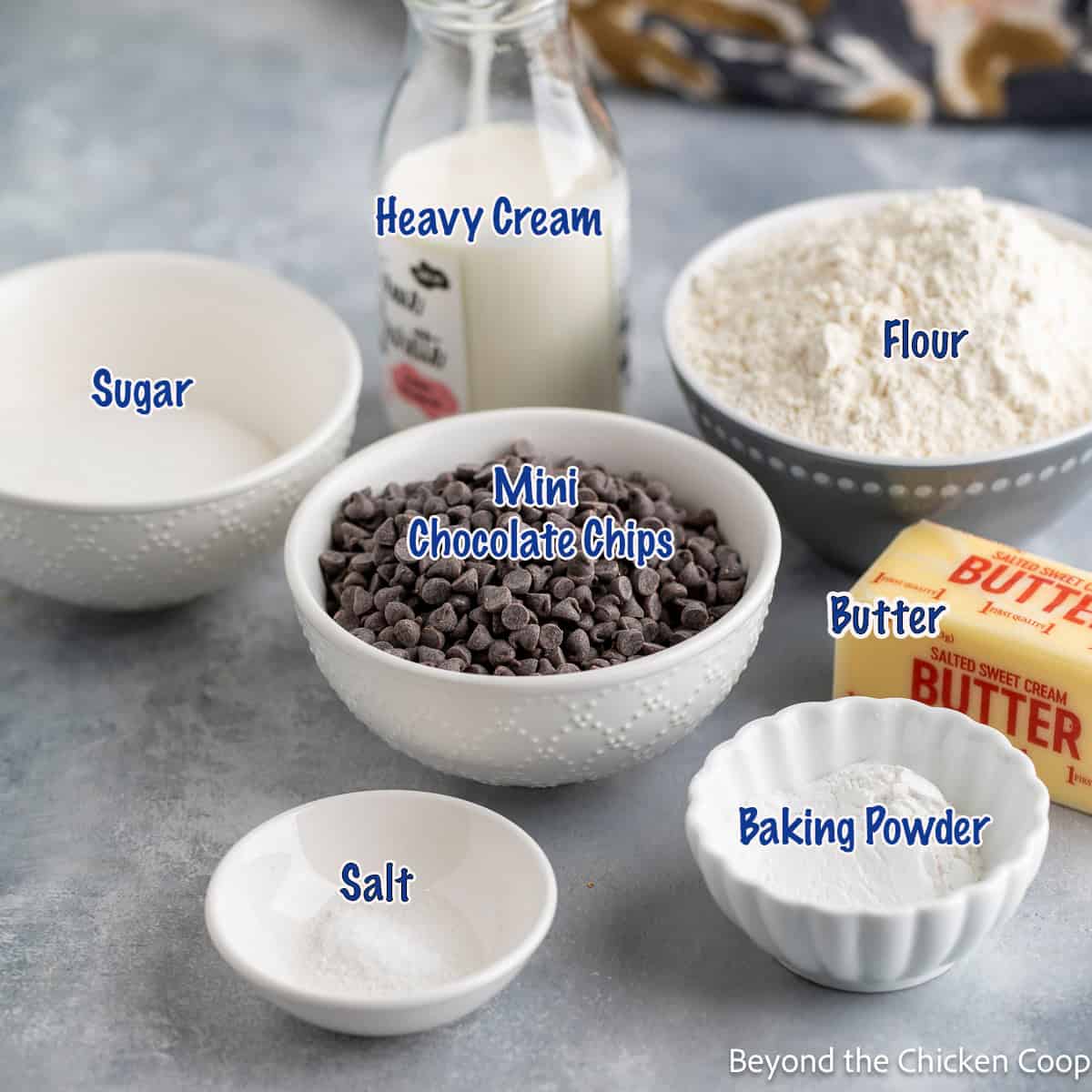 Small bowls filled with flour, sugar, chocolate chips, and other baking ingredients.