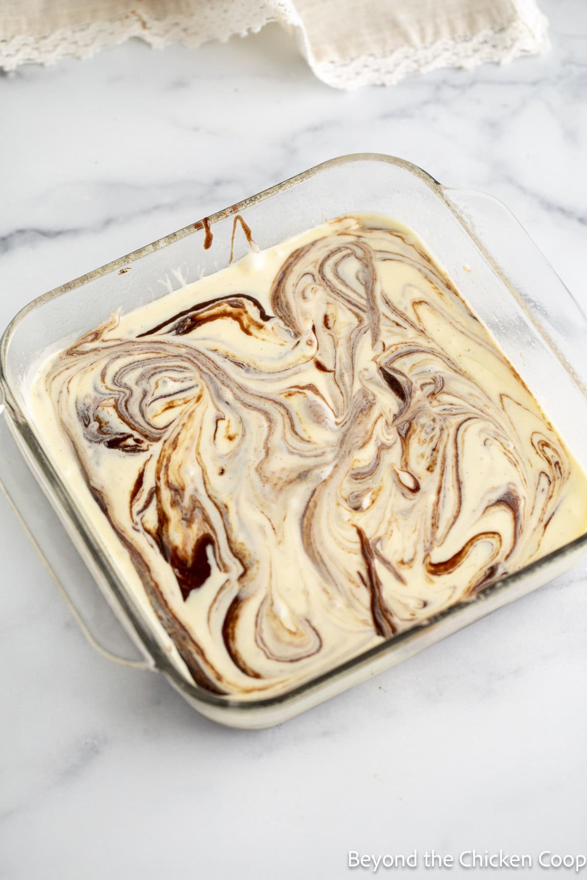 Swirled batters in a glass casserole dish.