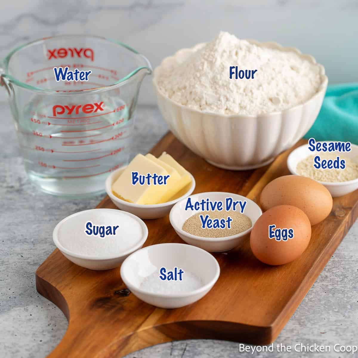 Bowls filled with flour, sugar, salt, and yeast for making bread.