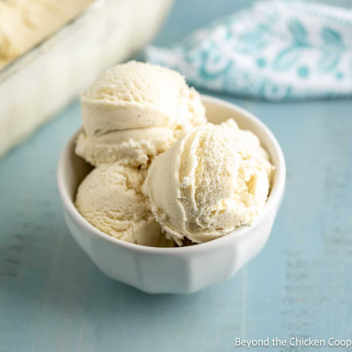 A bowl filled with scoops of homemade vanilla ice cream.