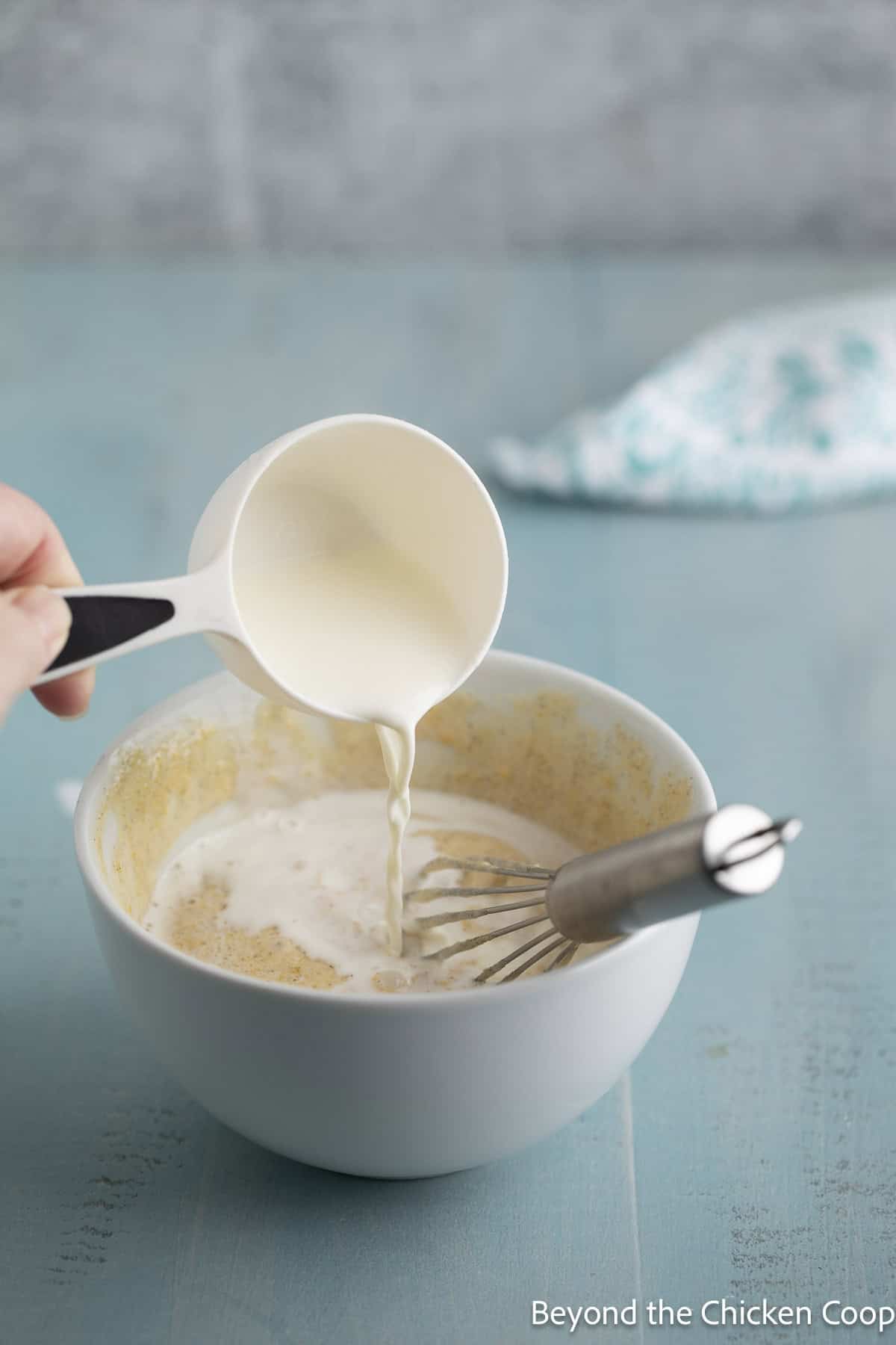 Pouring milk into a small bowl.