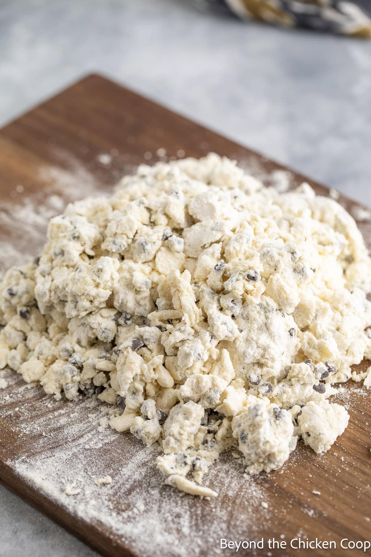 Flour with butter and chocolate chips on a wooden board.