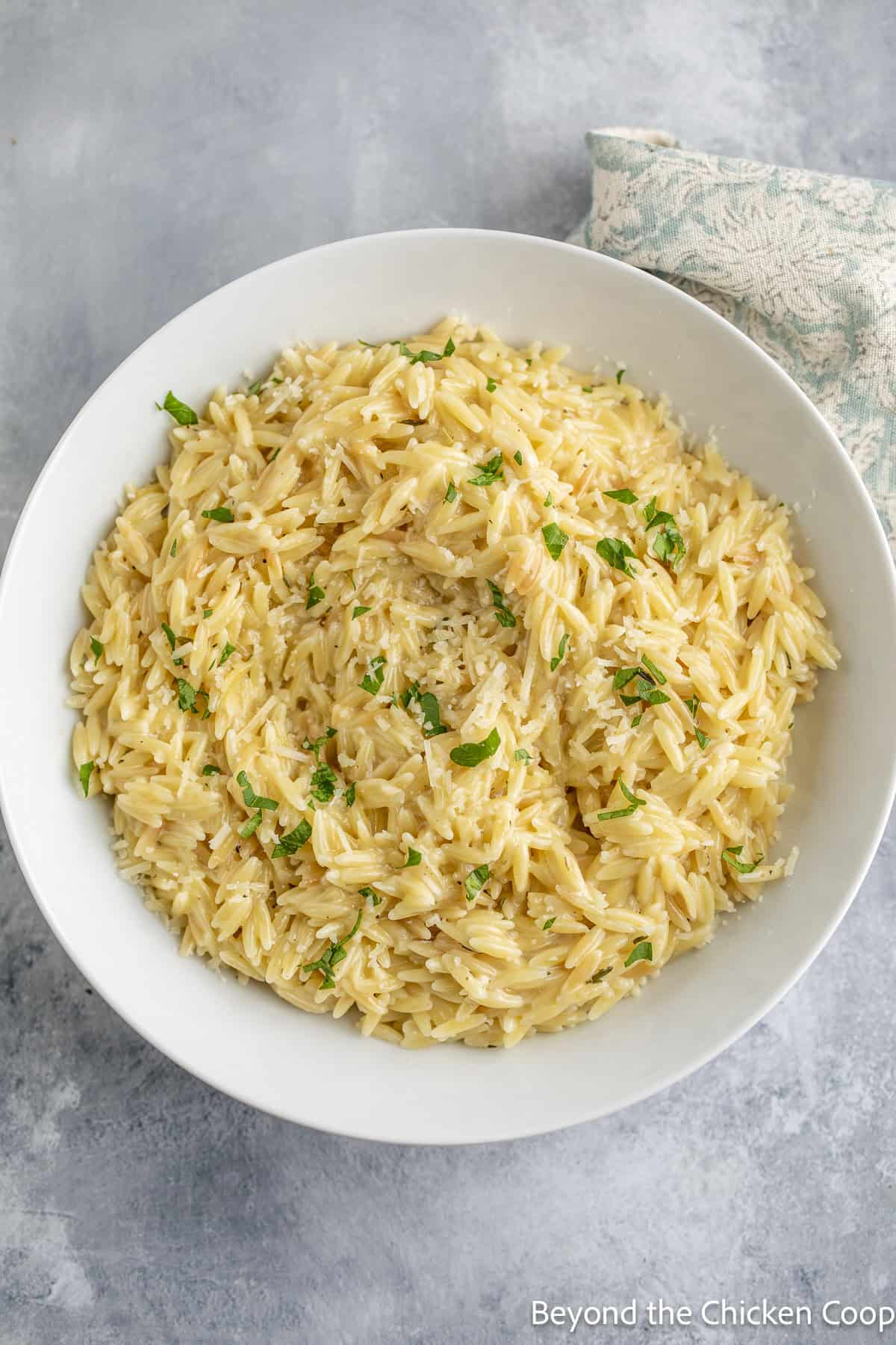 A white bowl filled with orzo pasta.