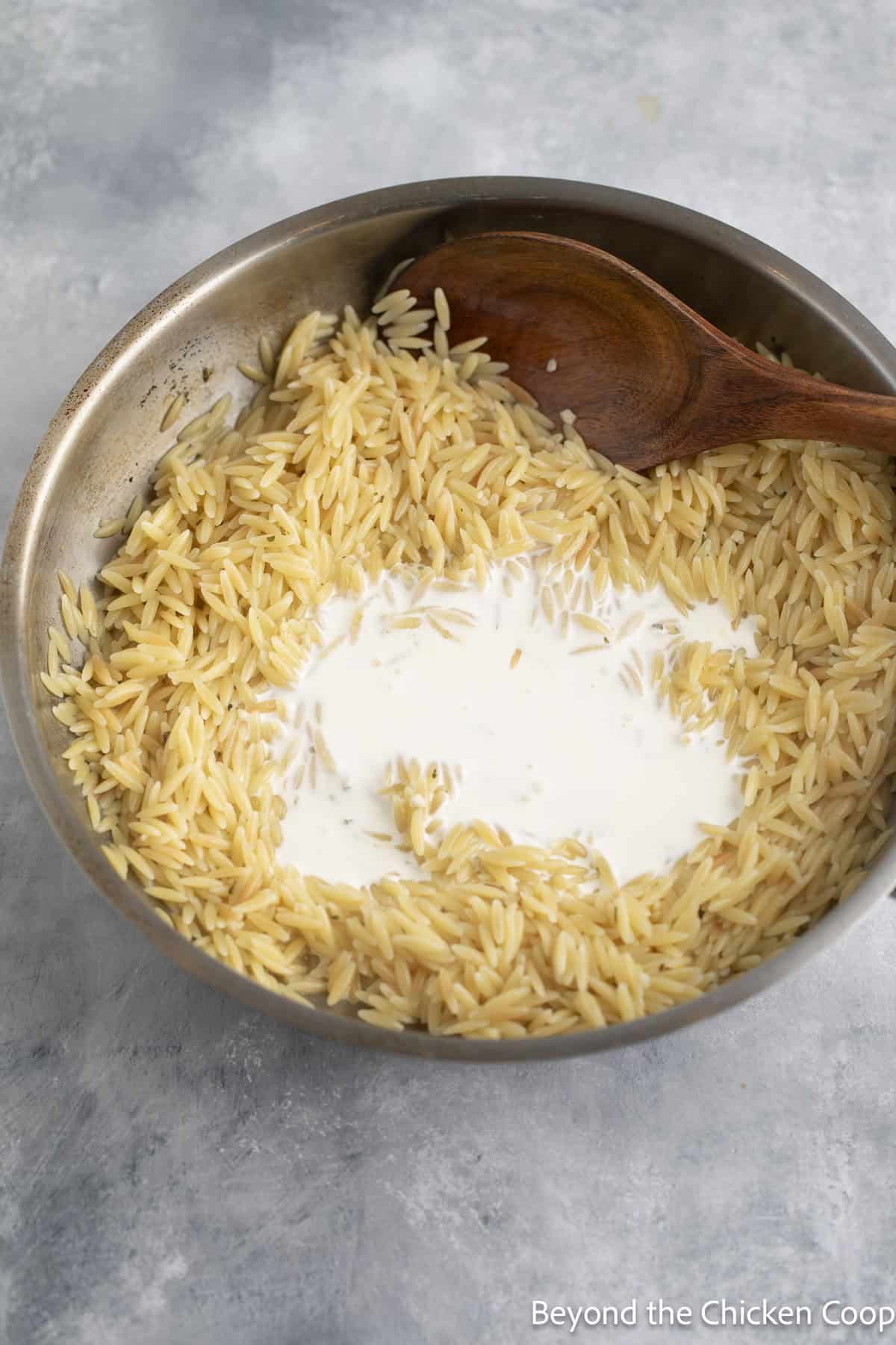 Cream in a skillet with pasta.