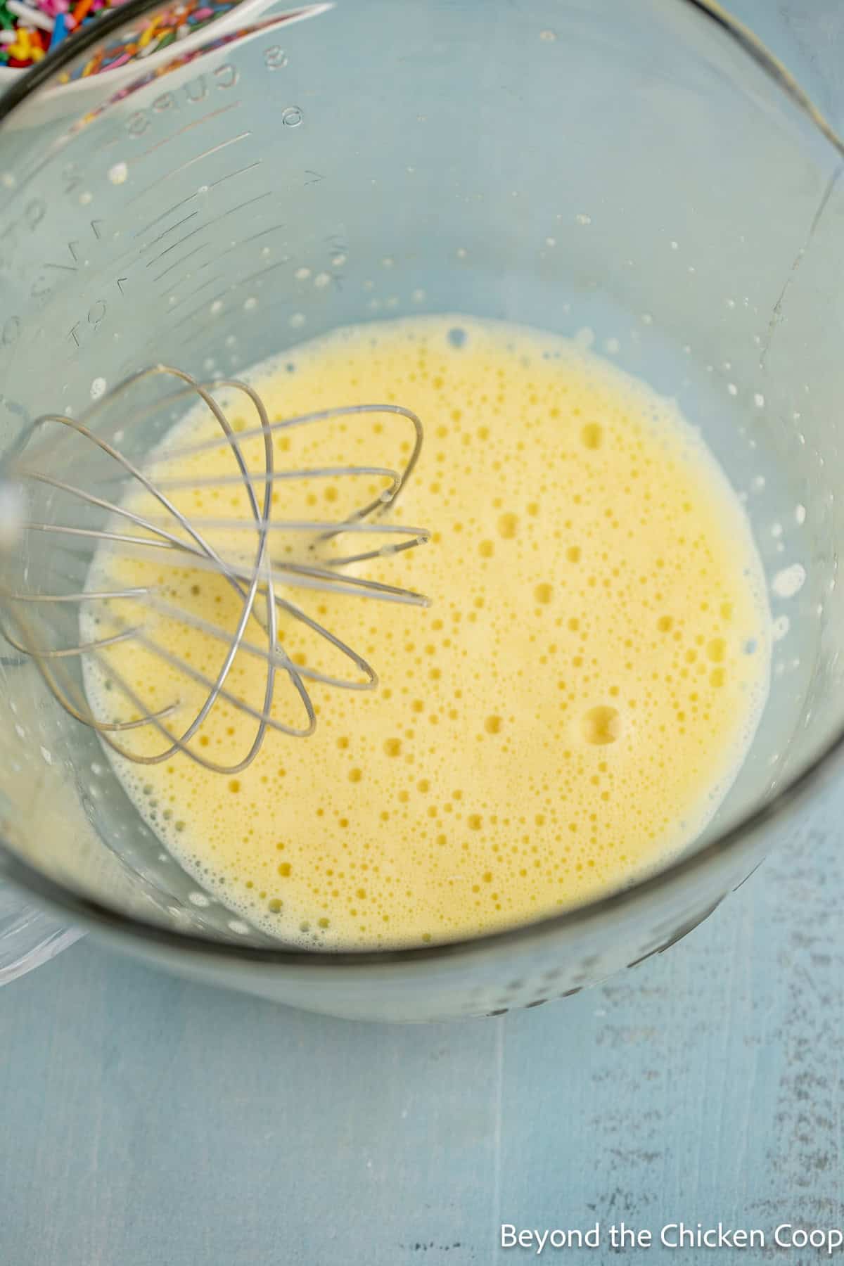 Whisked eggs in a glass bowl.