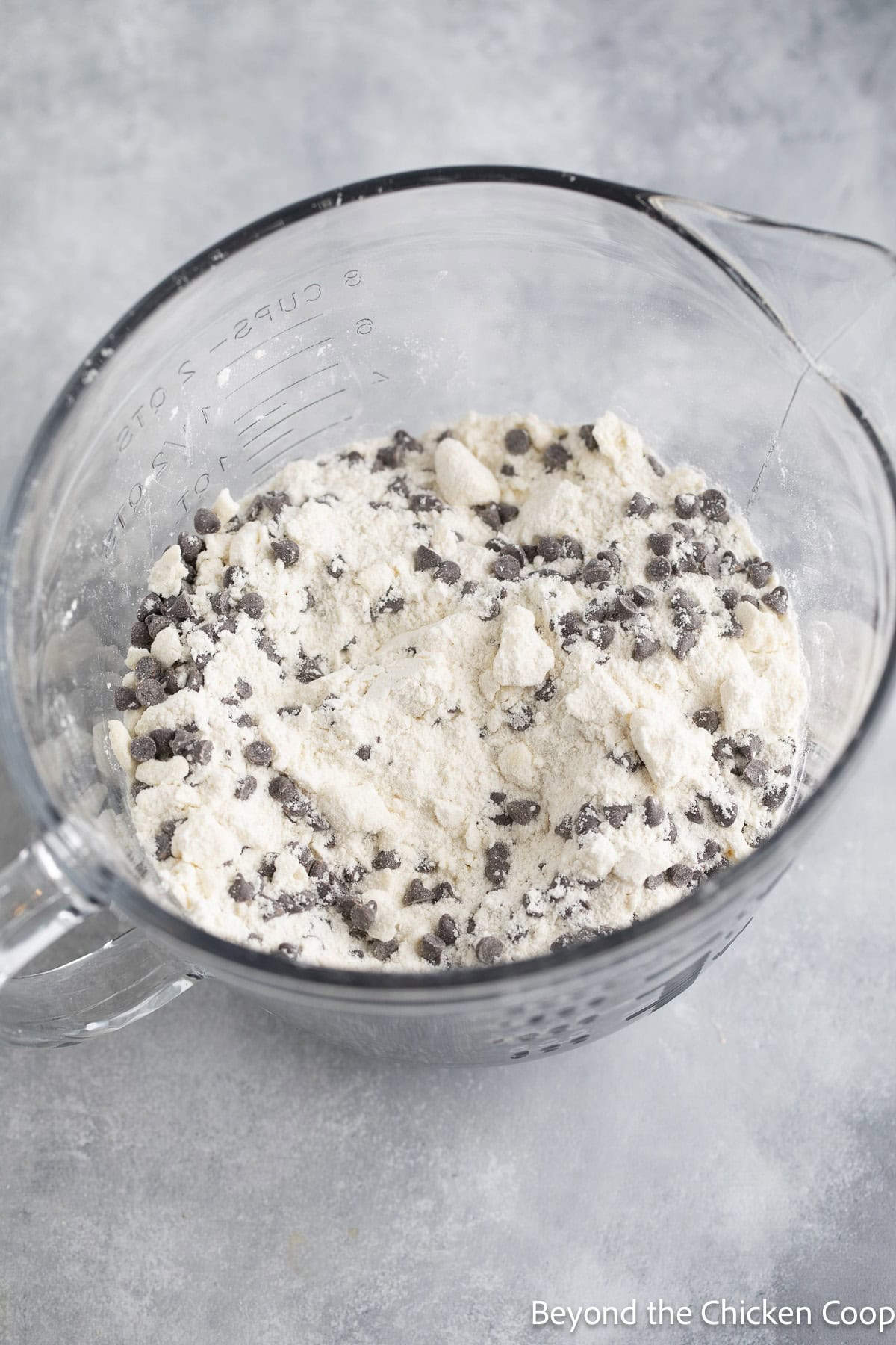 Chocolate chips with flour in a glass bowl.