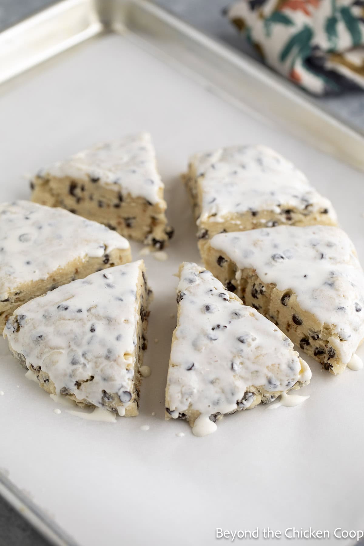Wedges of unbaked scones on a baking sheet.