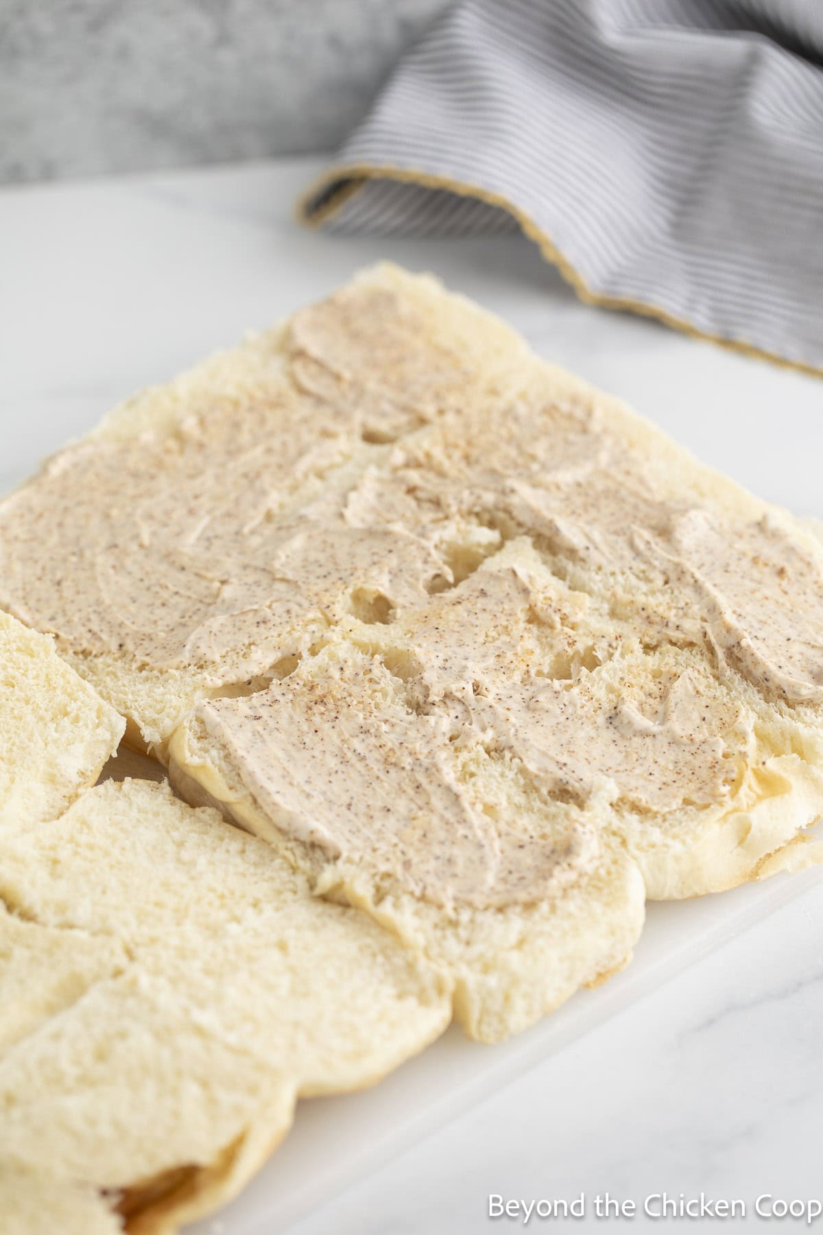 Slider buns cut in half and topped with mayonnaise.