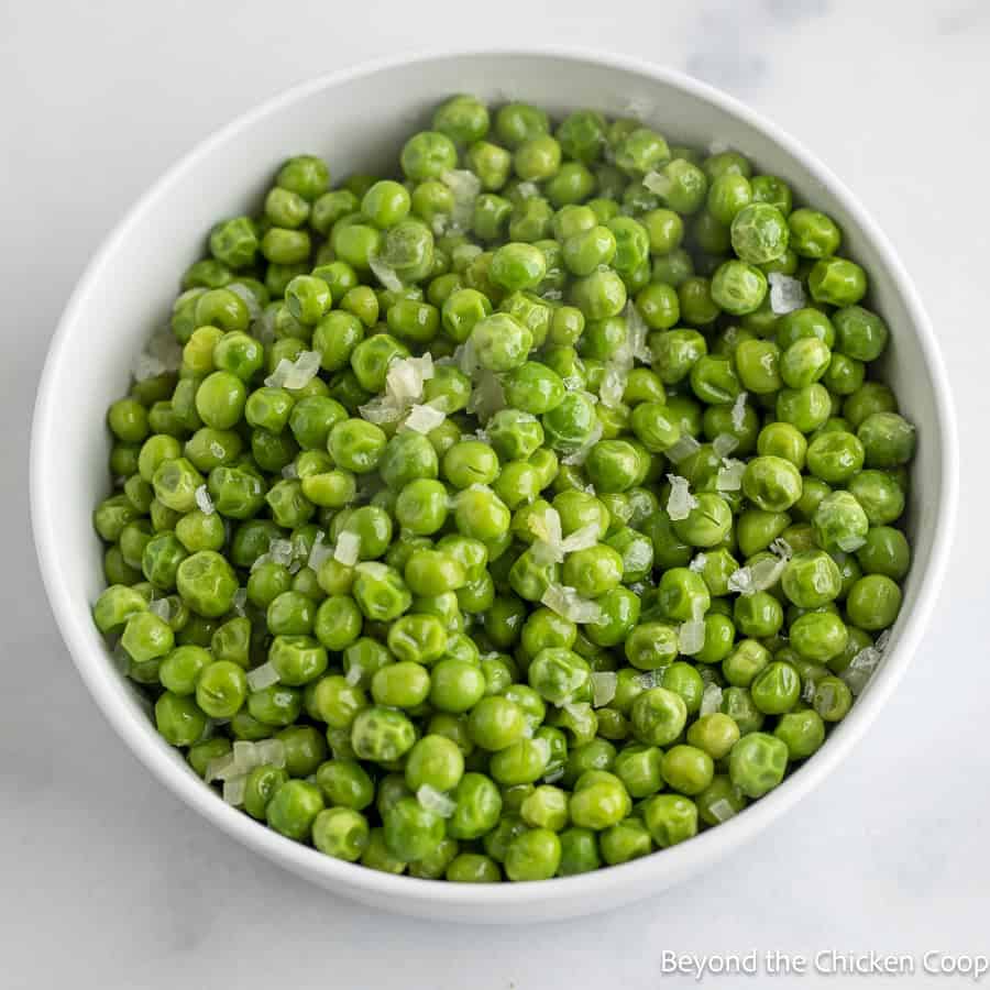 Buttered Peas in a white bowl. 