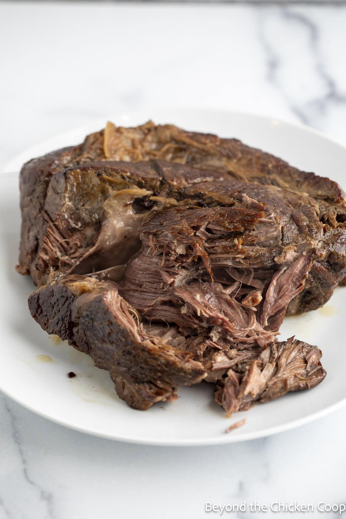 A cooked chuck roast on a plate.