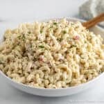 A creamy classic macaroni salad in a large white bowl.