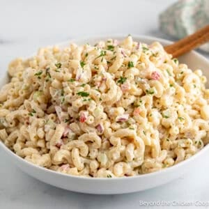 A creamy classic macaroni salad in a large white bowl.