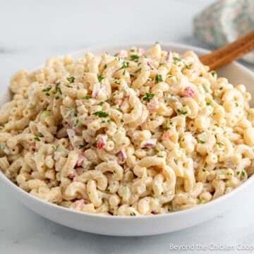 A creamy classic macaroni salad in a large white bowl.