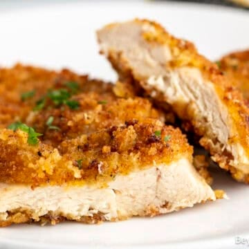 Crispy Chicken breasts sliced thinly on a white plate.