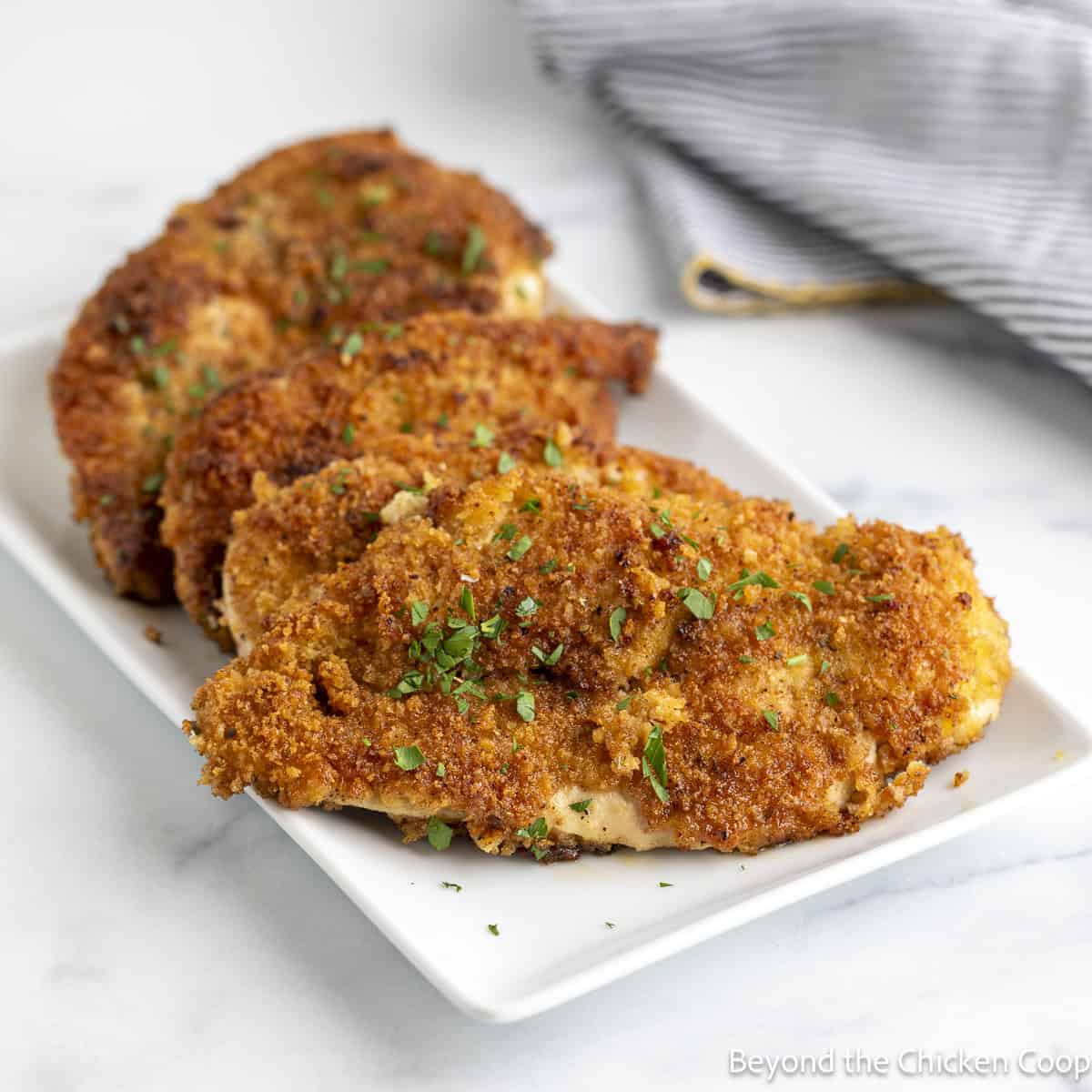 Crispy Chicken Cutlets on a white platter.