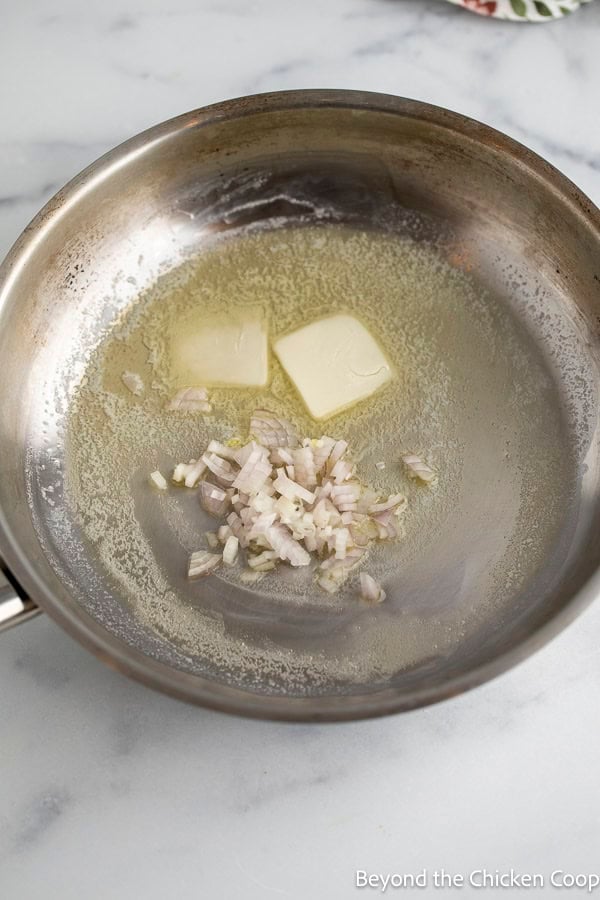 A sautee pan butter and shallots.