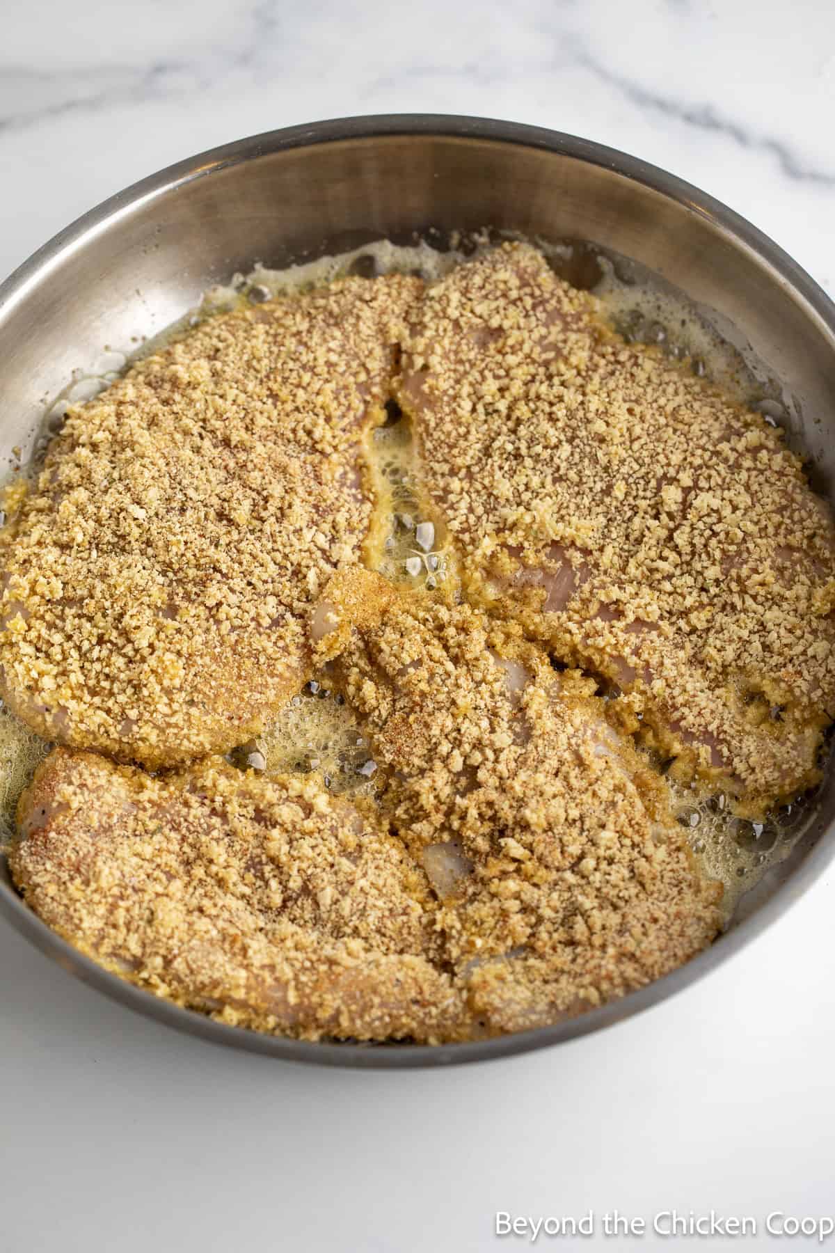 Cooking chicken in a skillet.