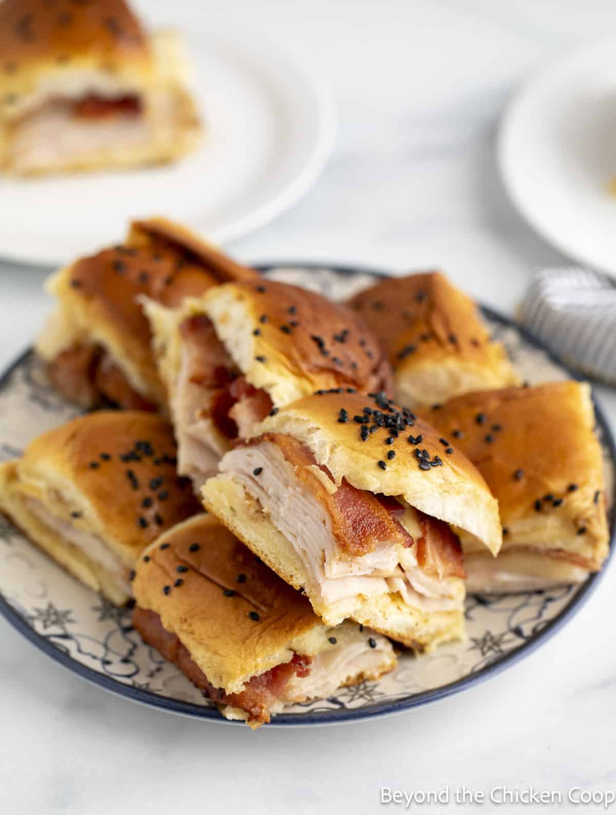 A plate of small turkey sandwiches.