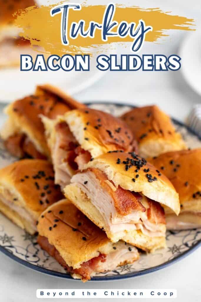 Small turkey sandwiches with bacon on a plate.