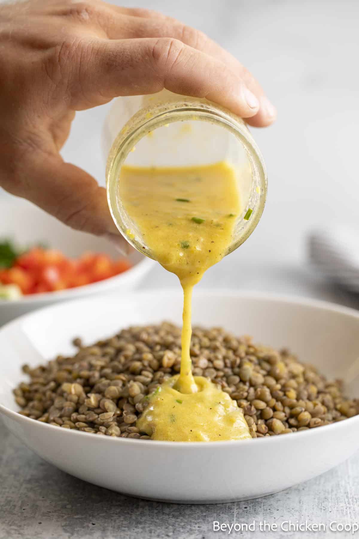 Pouring a dressing over cooked lentils.
