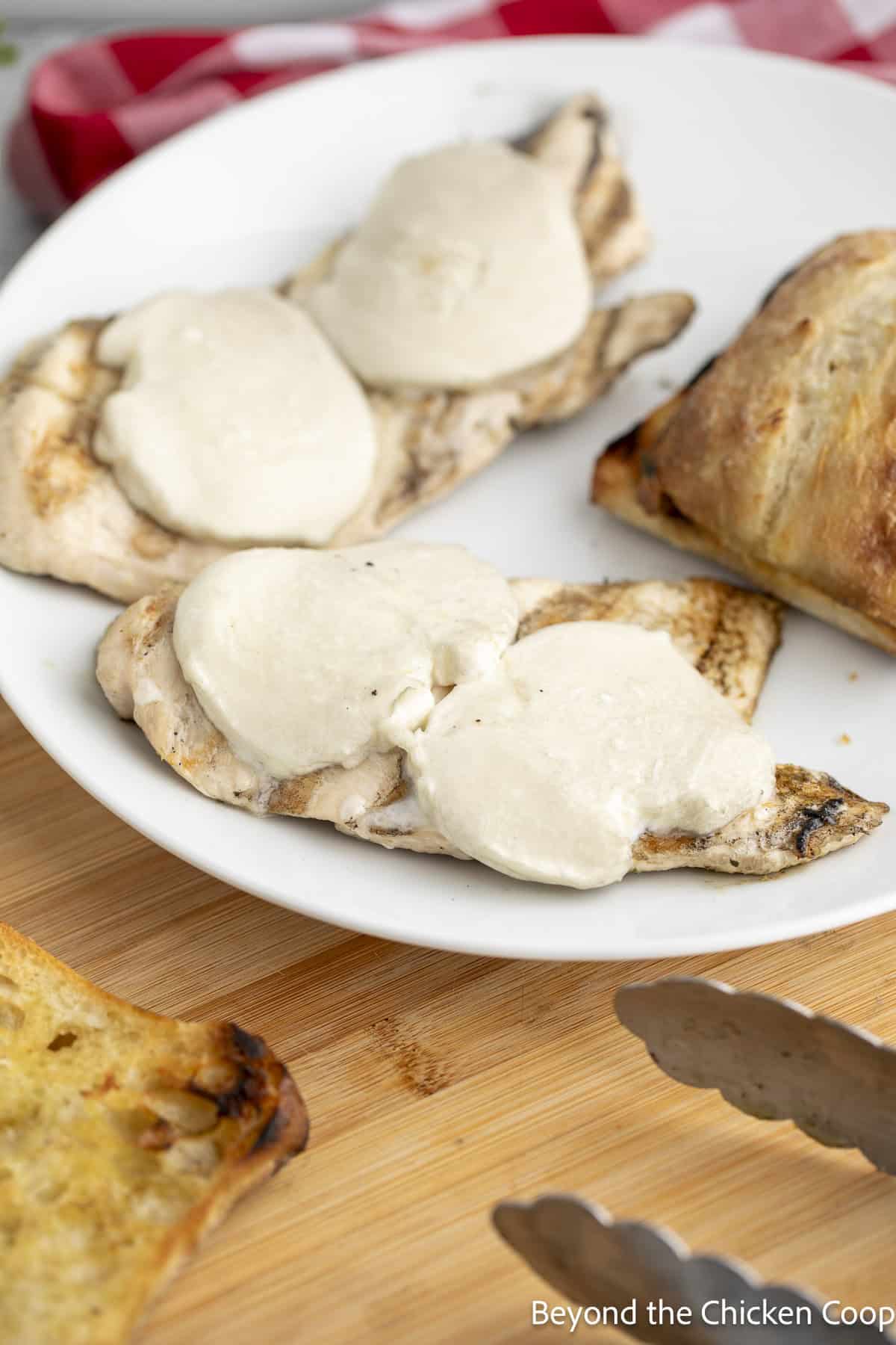 Chicken breasts topped with mozzarella cheese.