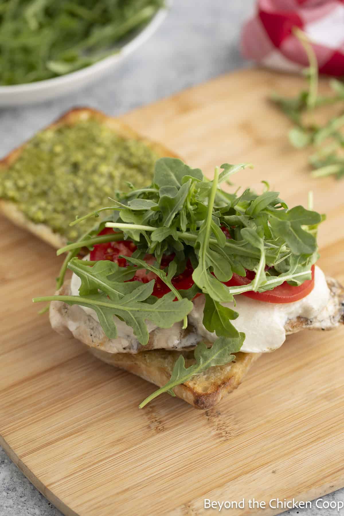 Arugula added to a sandwich.