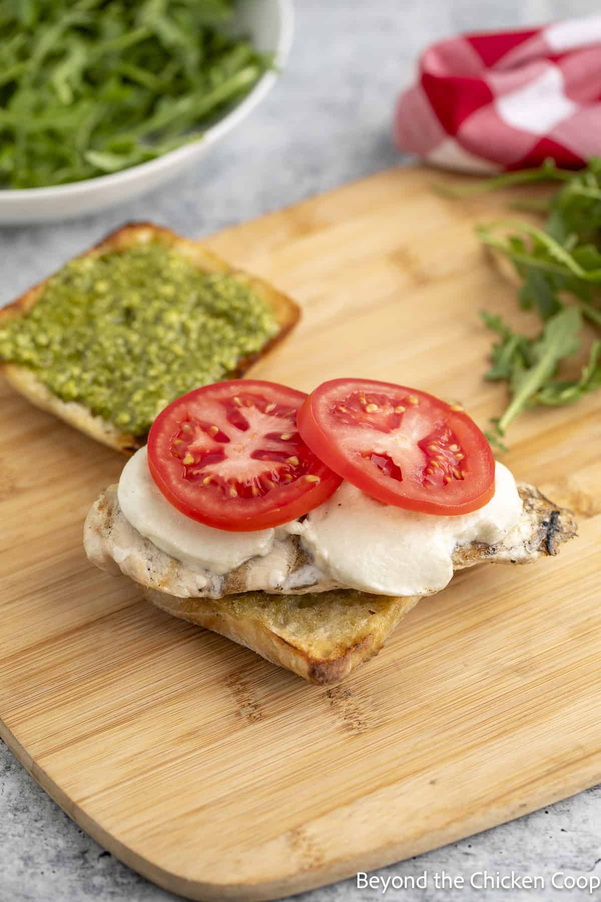 Chicken, tomatoes and cheese on a bun.