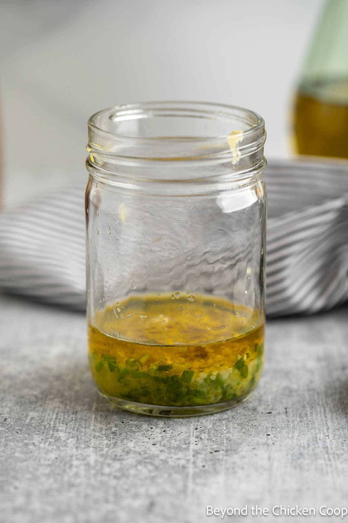 Oil, herbs, and mustard in a glass jar.
