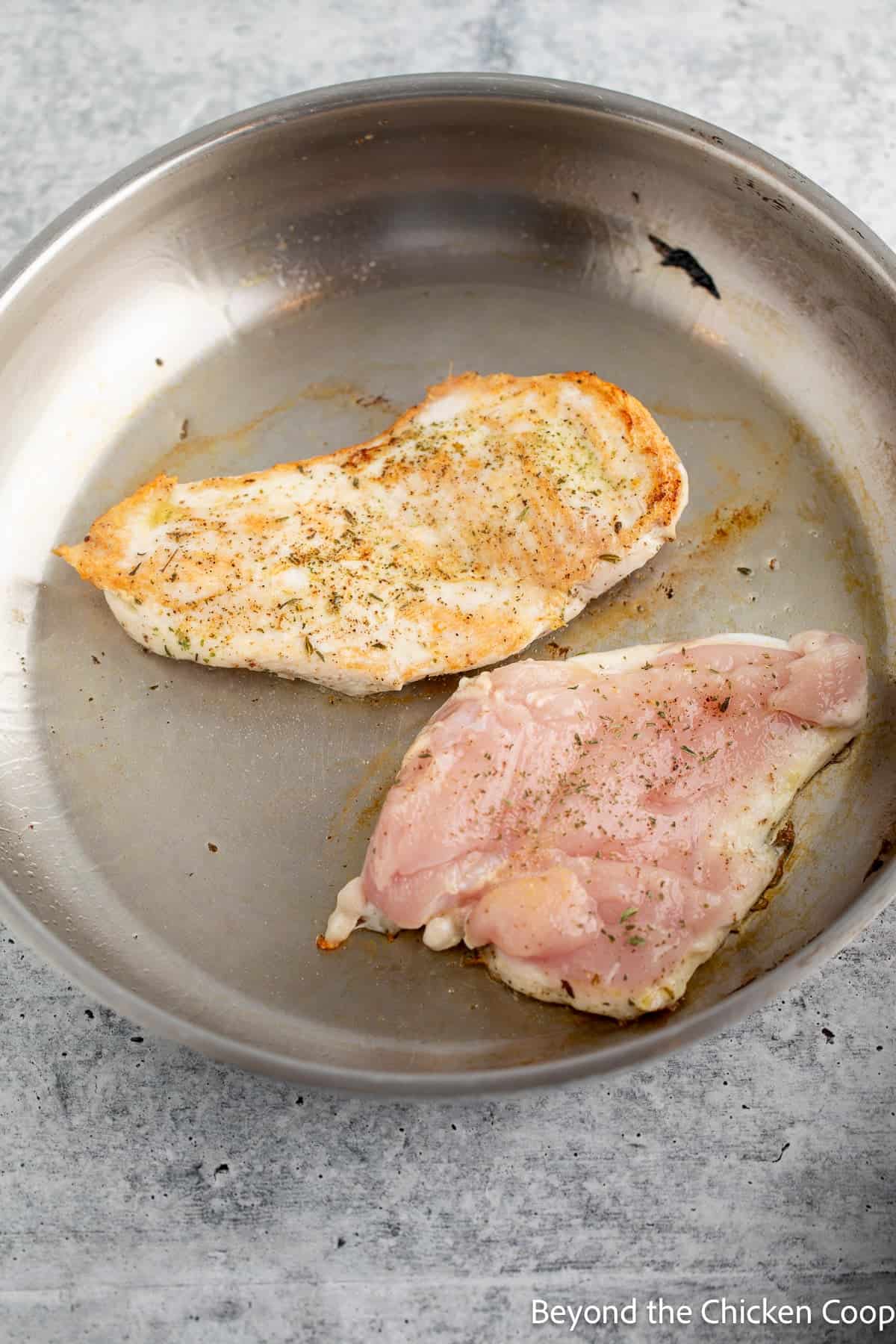 Cooking chicken breasts in a skillet.