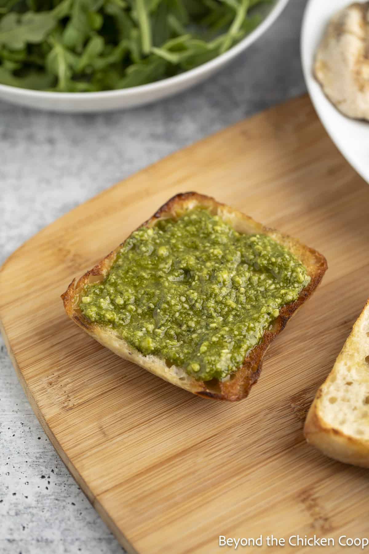 Pesto on top of a ciabatta roll.