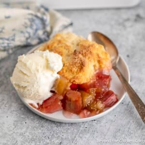 Rhubarb Cobbler with vanilla ice cream on a plate with a spoon.