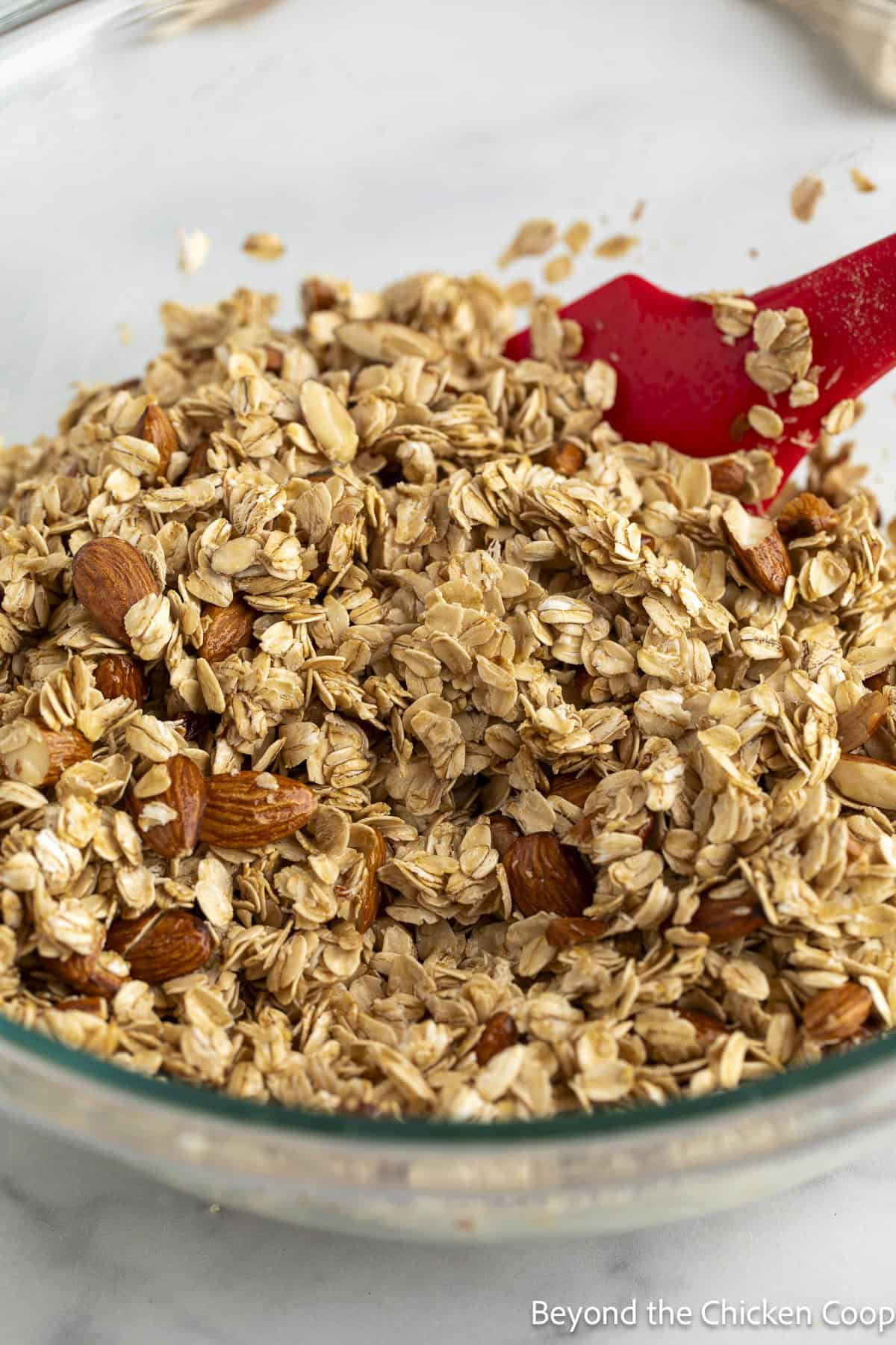 Oats and almonds mixed together in a large bowl.