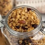 Honey Almond Granola with dried cranberries in a glass crock.