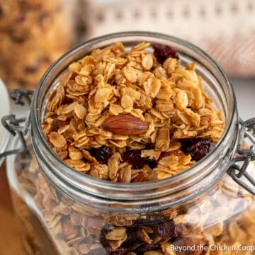 Honey Almond Granola with dried cranberries in a glass crock.