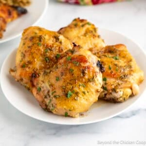 Honey Dijon Chicken thighs on a white plate.