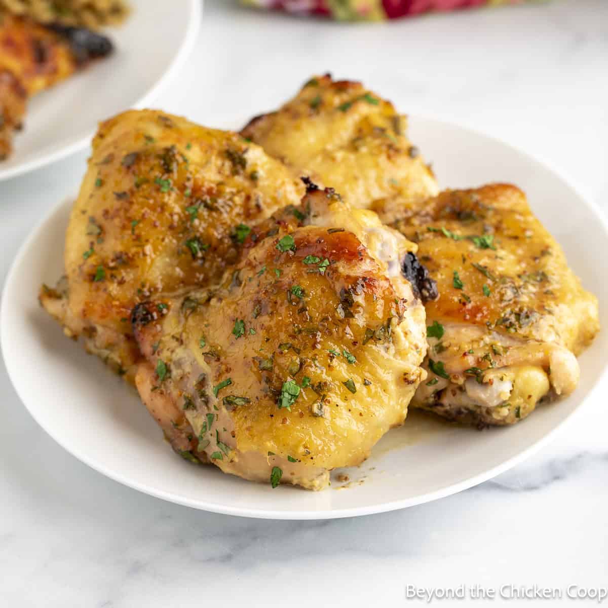 Honey Dijon Chicken thighs on a white plate.