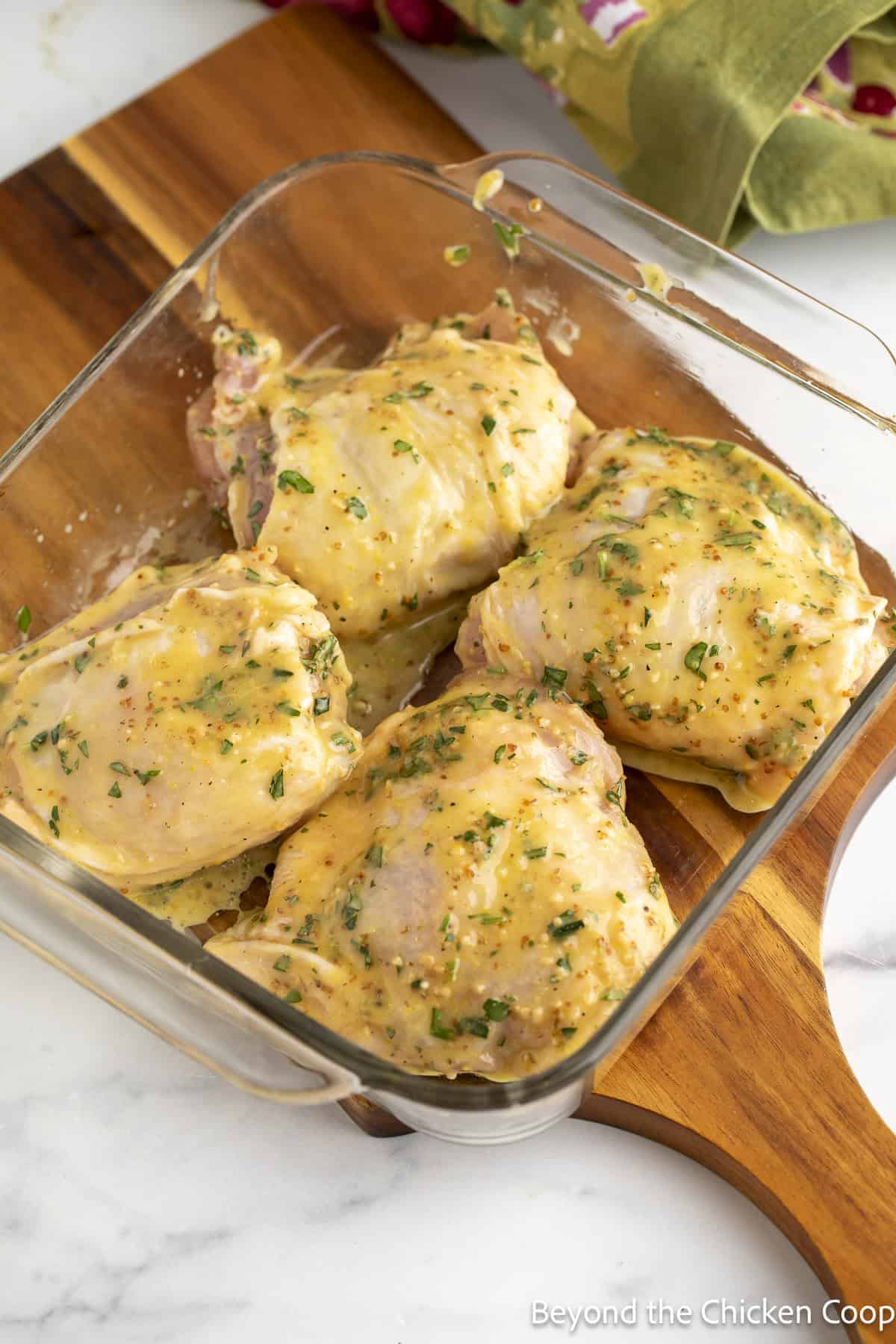 Chicken thighs in a glass baking dish.