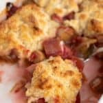A white casserole dish filled with rhubarb cobbler.