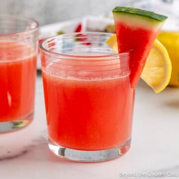Watermelon Lemonade in a glass with a small watermelon wedge as a garnish.